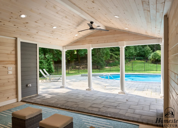 Open area of the pool house with large windows or doors, offering a view of the pool