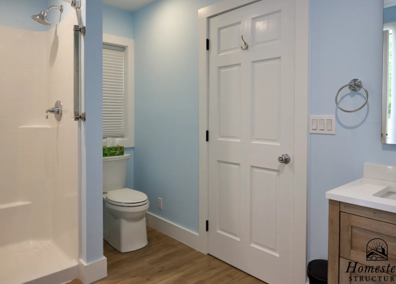 Pool house bathroom featuring a shower and toilet, designed for convenience and comfort