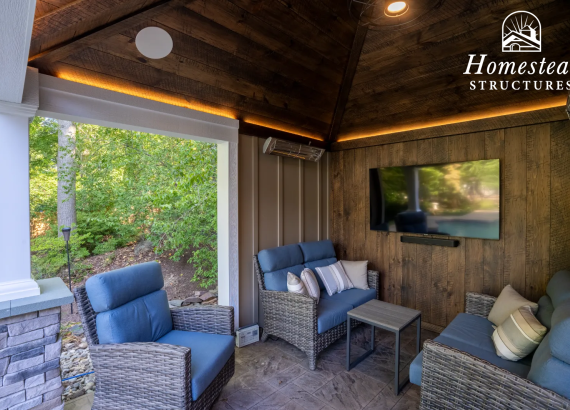 Cozy Outdoor Living Space with TV and Stylish Furniture Underneath a Custom Pool House